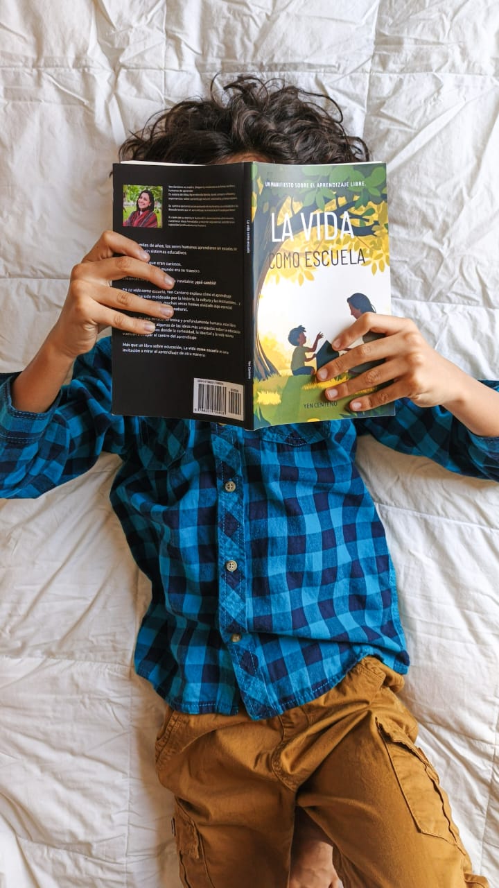 Niño leyendo el libro La vida como escuela sobre aprendizaje libre y unschooling