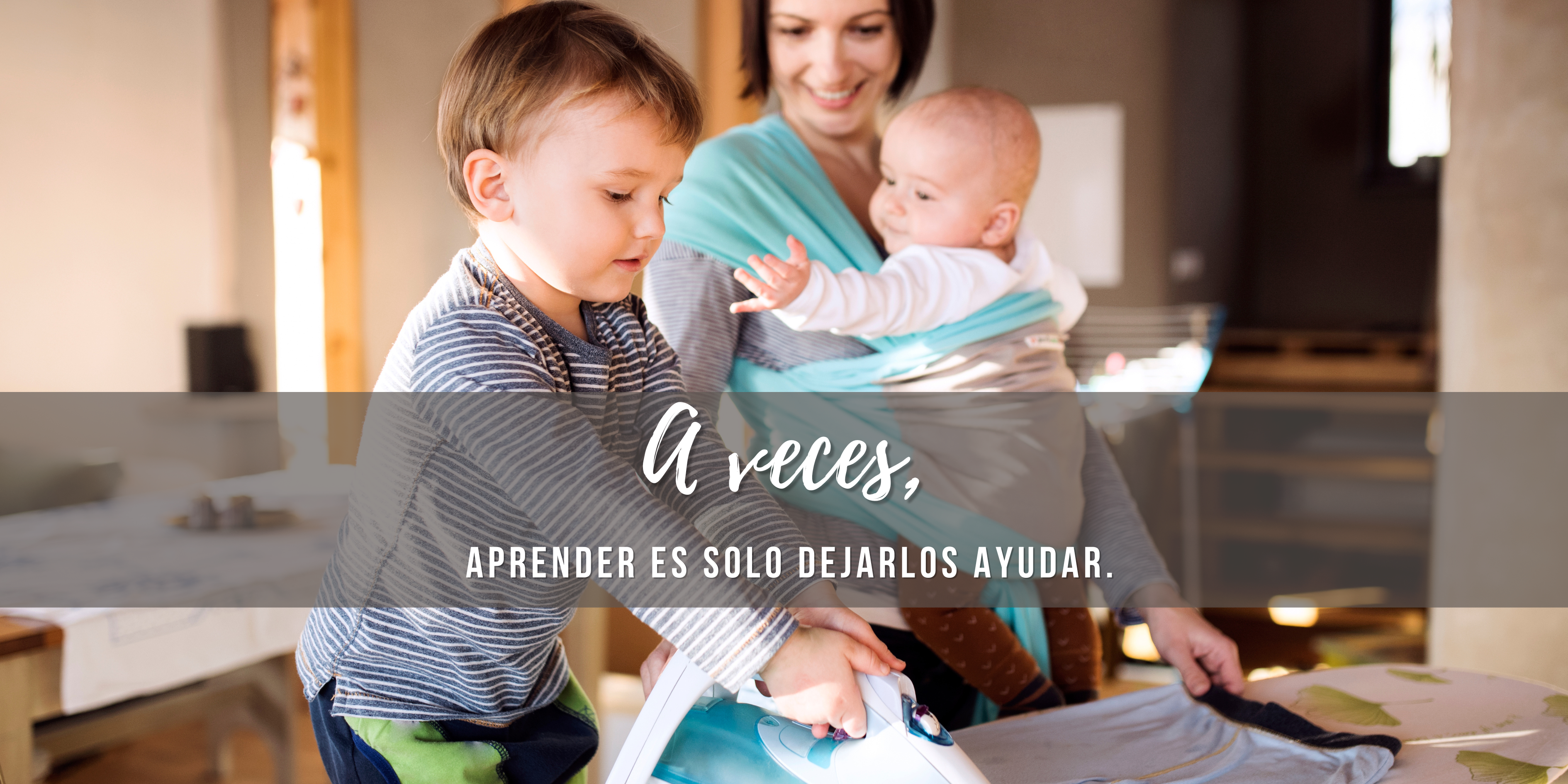 Niño pequeño ayudando a planchar junto a su madre que carga a su bebé en portabebé, tareas domésticas y unschooling