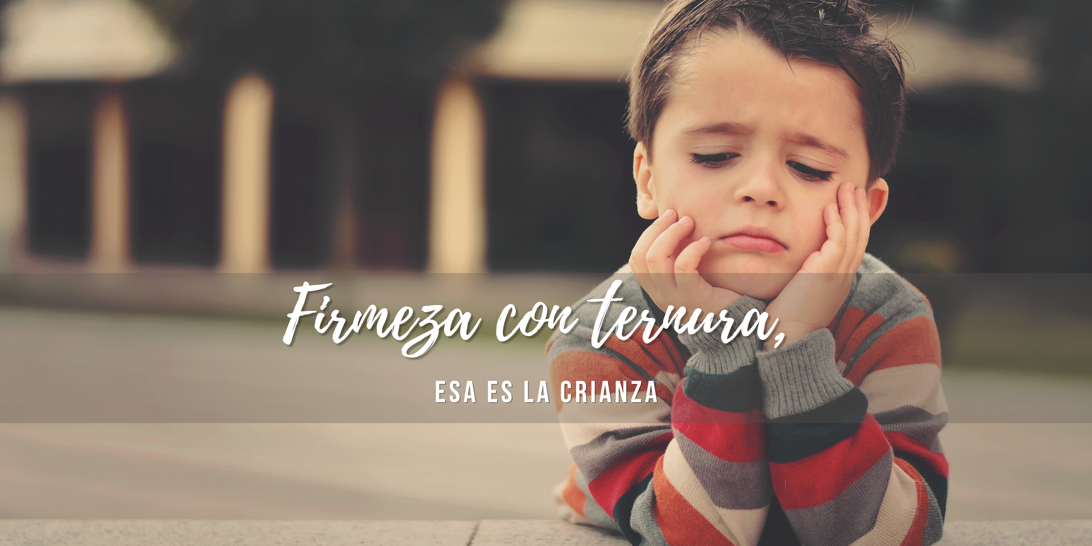 Niño sentado en una plaza con el rostro apoyado en las manos, gesto de enojo y tristeza, crianza respetuosa