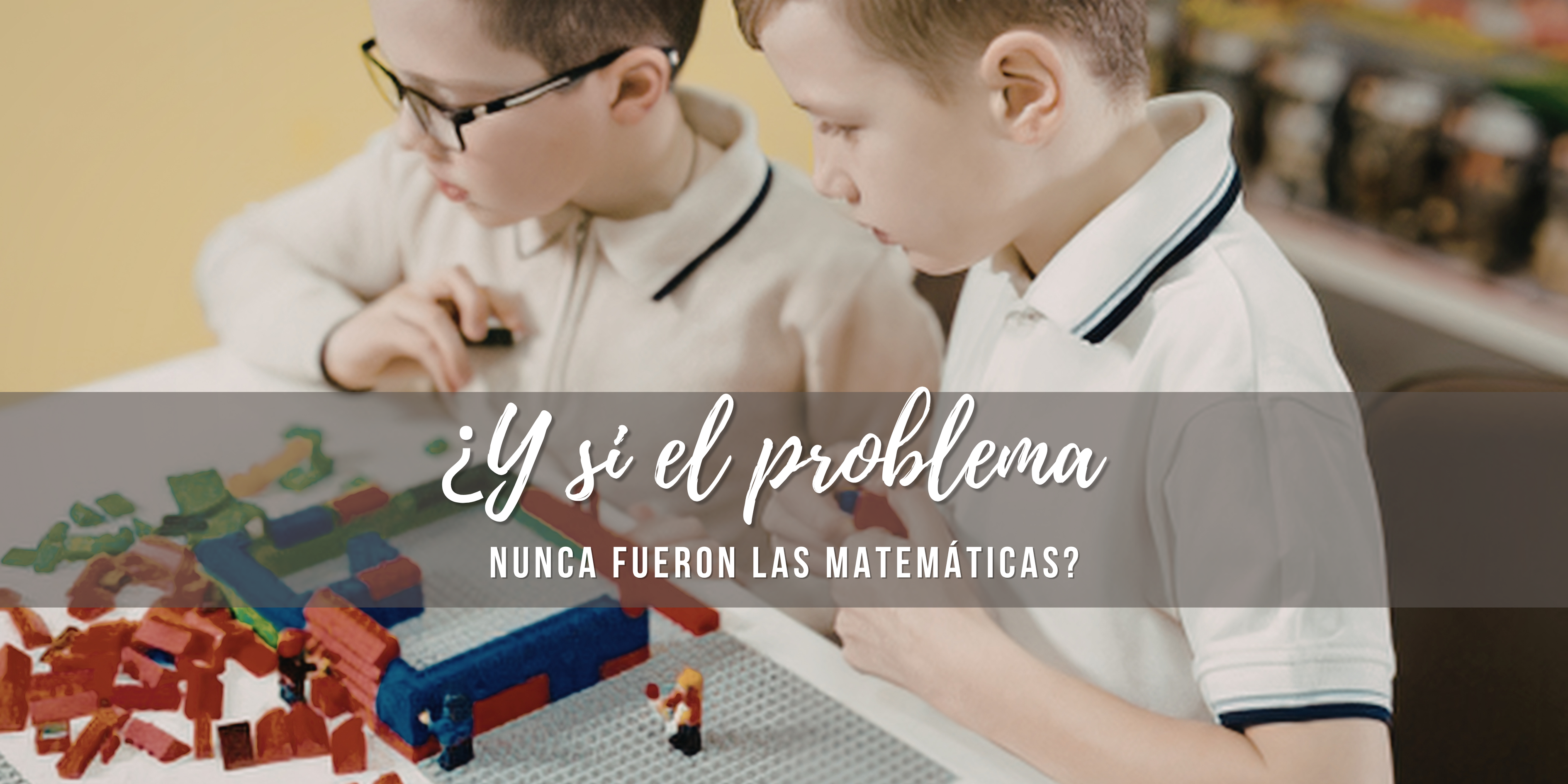 Dos niños sentados construyen con piezas de LEGO mientras resuelven juntos un problema.