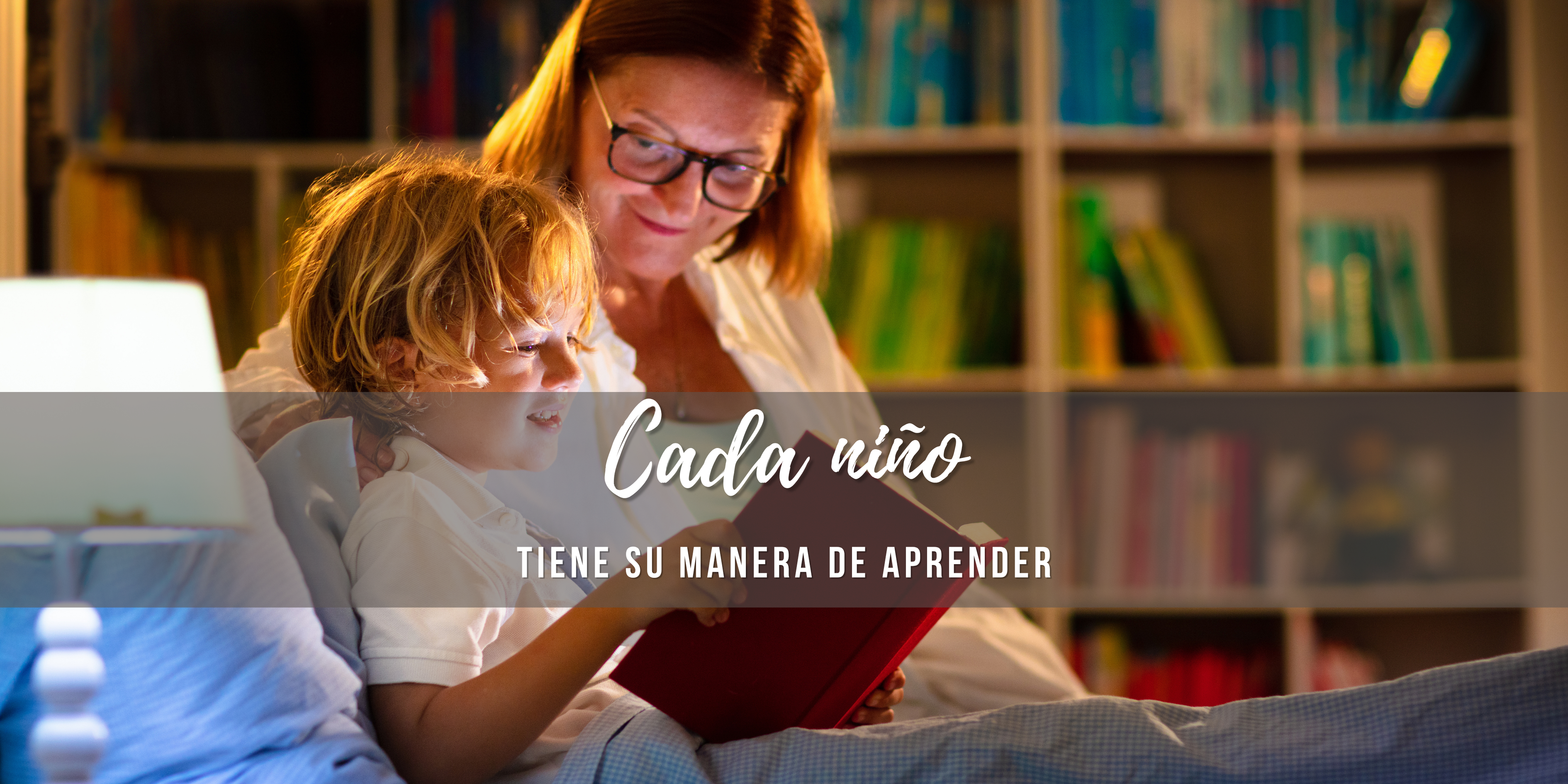 Madre y niño comparten un momento de lectura antes de dormir; el niño sostiene un libro mientras ella lo observa con atención.