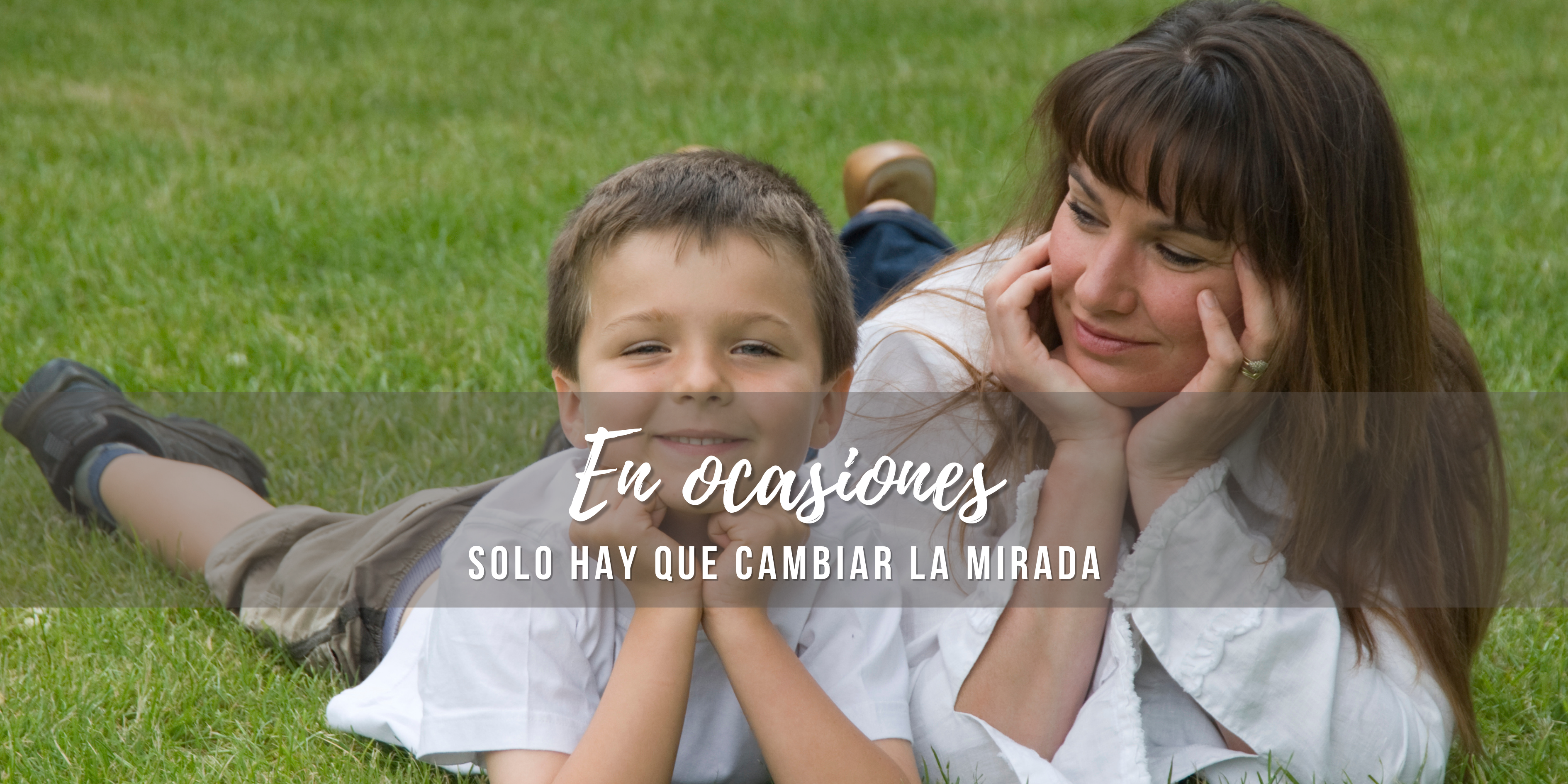 Madre e hijo tumbados en el césped. Ella le mira como si comprendiera el mundo y la vida a través de sus ojos